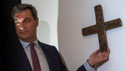 Bild: Peter Kneffel/dpa/Archivbild
Markus Söder hängt ein Kreuz im Eingangsbereich der bayerischen Staatskanzlei auf.