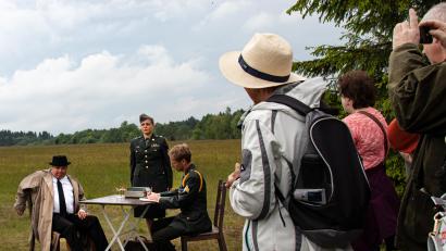 Bild: sfo
Eine Station auf der Route der geführten Schauspielwanderung bei Bärnau/Pavlova Hut'. Der falsche amerikanische Offizier Captain Simpson (Stefan Hertwig, sitzend rechts) verhört den Flüchtenden Emanuel Valenta (Marek Velebný, sitzend links). Mit am Verhörtisch steht eine tschechoslowakische Staatssicherheits-“Dolmetscherin“ (Silvia Siebert).