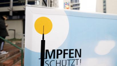 Bild: Bernd Weißbrod/dpa/Symbolbild
Blick auf ein Plakat mit der Aufschrift „Impfen schützt“ vor einem Impfzentrum.