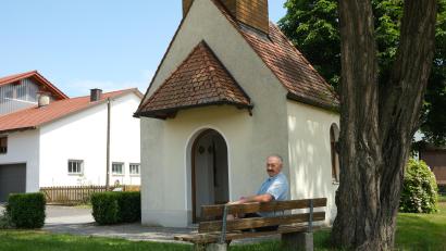 Bild: Hirsch
Der Vorsitzende des "Kapellenvereins Wohlfest", Johann Hermann, nimmt gerne Platz auf dem Bankerl vor der Marienkapelle. Seit 25 Jahren kümmert er sich um den Erhalt des Kirchleins und um die Pflege der Außenanlagen.
