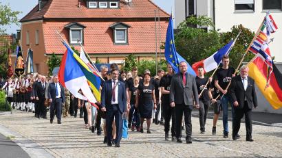 Bild: gf
Anlässlich der Besiegelung der Städtepartnerschaft geht es im Festzug durch Freihung, voran die Fahnen der beteiligten Nationen sowie die von Europa und der Ukraine. Voran schreiten (von links) Volksbund-Geschäftsführer Dario Vidojakovic, Freihungs Bürgermeister Uwe König und Vorsitzender Hartmut Schendzielorz.