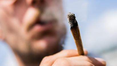 Bild: Christoph Soeder/dpa
Ein Mann raucht bei der Auftaktkundgebung einer Demonstrationen für eine zügige Legalisierung von Cannabis, dem „Global Marijuana March 2022“, am Brandenburger Tor einen Joint mit Medizinalcannabis.