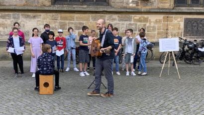 Bild: ero
EG-Musiklehrer Sebastian Birner mit einem kleinen Auftritt des Unterstufen-Chors am Amberger Marktplatz.