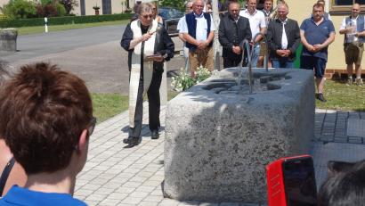 Bild: fjo
Der Pleysteiner Stadtpfarrer Pater Johann Ring segnet den neuen Pfrentschweiher-Brunnen beim Schützenhaus.