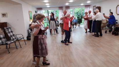 Bild: gi
Die Volkstanzpaare tanzen Polka, Walzer und Boarischen in der Wohnanlage an der Wieskirche. Die Bewohner tanzen mit und sparen nicht mit Applaus.
