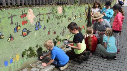 Bild: bnr
Mit Begeisterung bemalten die Schüler der Grundschule die Betonwand am Dorfladen. Angeleitet wurden sie dabei von Ernst Zimmerer.