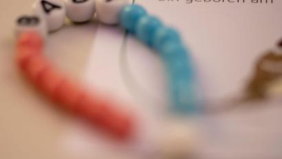 Symbolbild: Stefan Puchner/dpa
Ein Kettchen für ein Neugeborenes liegt im Kreißsaal einer Klinik.