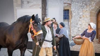 Bild: Michael Lang/ML-Weblive/exb
Das Gesinde im Burghof bemerkt, dass Räuberhauptmann Franz Troglauer ein stattliches Ross gestohlen hat und sich mit seiner Räuberbande aus dem Staub machen will.