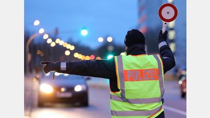 Symbolbild: Bernd Wüstneck/dpa
Ein Polizist hält ein Auto für eine Kontrolle an.