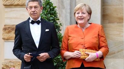 Bild: Daniel Karmann/dpa
Die ehemalige Bundeskanzlerin Angela Merkel und ihr Mann Joachim Sauer stehen vor dem Bayreuther Festspielhaus.