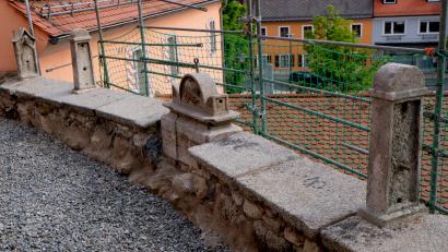 Bild: le
Ihren angestammten Platz haben die vier Fragmente früherer Grabdenkmäler des alten Simultanfriedhofes. Nach Anbringung des Metallgeländers und Sanierung des Bodenbereiches kann der Zugang rund um die evangelische Pfarrkirche St. Johannes Baptista wieder freigegeben werden.
