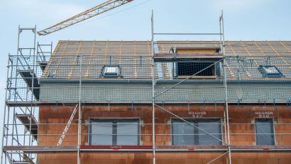 Symbolbild: Lino Mirgeler/dpa
Ein Baukran steht an einem neugebauten Haus. Auch in Plößberg lagen im Gemeinderat einige Bauanträge vor.