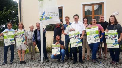 Bild: ld
Die Teilnehmerinnen und Teilnehmer präsentieren das Plakat für die Veranstaltung und ziehen die Fahne auf, die von dem großen Ereignis kündet.