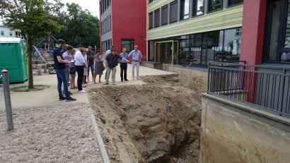 Bild: ui
Der Neustädter Bauausschuss besichtigt die aufgegrabene Fassade der Grundschule.