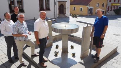 Bild: bl
Die Bürgermeister (vorne von links) Frank Zeitler, Richard Tischler und Josef Deichl appellieren zusammen mit den Wasserwarten Stephan Lobinger (Pfreimd) und Erwin Lobinger (Nabburg) (rechts) an die Bürger, Trinkwasser zu sparen. Ebenso wie Pfreimd hat Nabburg vor wenigen Tagen wegen der Knappheit die Springbrunnen (im Bild der Brunnen vor dem Rathaus) stillgelegt.
