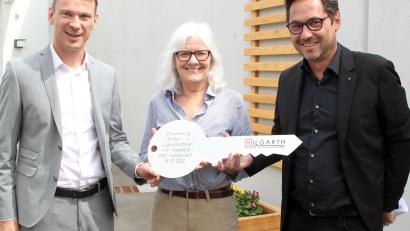 Bild: lst/exb
Architekt Peter Hilgarth (rechts) überreicht an HPZ-Vorstandsvorsitzenden Christian Stadler und an die stellvertretende Aufsichtsratsvorsitzende Daisy Brenner nicht nur offiziell den Schlüssel für das Kinder- und Jugendwohnen „Am Kleefeld“, sondern auch einen Spendenscheck über 2500 Euro.