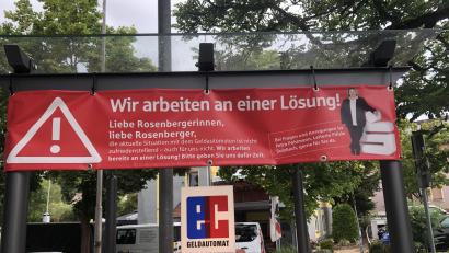 Bild: oy
"Wir arbeiten an einer Lösung!", steht auf einem Banner der Sparkasse über dem Geldautomaten in Rosenberg. Offenbar ist die Sparkasse um Schadensbegrenzung bemüht - bei vielen Bürgern sorgte der Automat zuletzt nämlich für Ärger und Kritik.