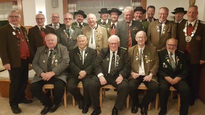 Bild: gi
Bezirksschützenmeister Harald Frischholz (stehend, rechts) sowie sein Stellvertreter Bernhard Auburger (links) ehren langjährige Schützen.