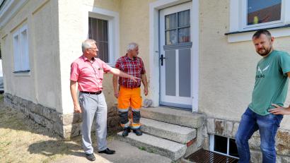 Bild: njn
Bauhofmitarbeiter Werner Bregler (Zweiter von links) hat in den vergangenen Tagen sämtliche Türen und Fenster des Leichenhauses gestrichen. Jetzt geht es in einem weiteren Schritt um den Außenputz und den Granitsockel. Mit auf dem Bild (von links) Bürgermeister Johannes Reger und Technischer Angestellter Markus Meyer.