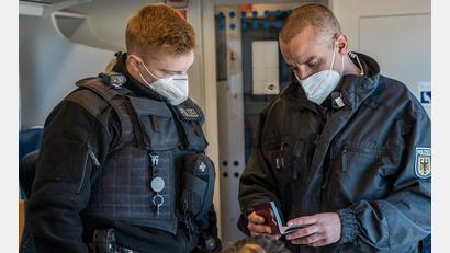 Bild: Bundespolizei
Zwei Beamte der Bundespolizei kontrollieren Ausweise in einem Zug.