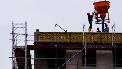Symbolbild: Soeren Stache/dpa-zentralbild/dpa
Arbeiter stehen auf einer Baustelle eines Wohngebäudes.