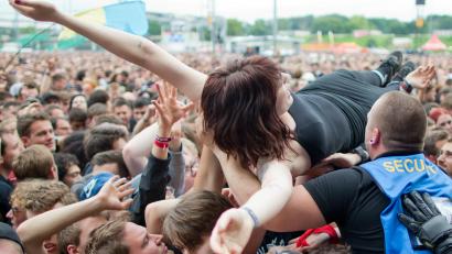 Symbolbild: Daniel Karmann/dpa
Eine Festival-Besucherin lässt sich während eines Konzerts beim Crowdsurfing über die Menge tragen.