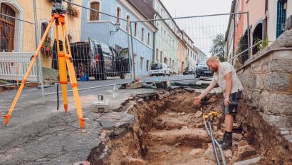 Bild: sfo
Archäologe Matthias Hoffmann von der Firma In Terra Veritas aus Weiden deutet auf einen Bereich in der Bärnauer Silberstraße. An dieser Stelle sind Steinblöcke der früheren Stadtmauer entnommen worden. Vor der Sanierung des Silberbergs wurden in zwei Abschnitten der Straßen archäologische Untersuchungen durchgeführt.