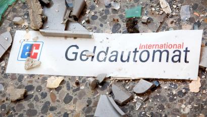 Bild: Patrick Pleul/zb/dpa
Splitter und ein Schild mit der Aufschrift „Geldautomat“ liegen auf dem Fußboden.