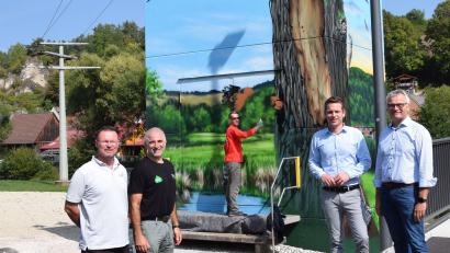 Bild: bö
In Hohenburg gehen Kunst und die Sanierung des Trafohauses Hand in Hand. Markus Ronge (Mitte hinten) von ART-EFX ist hier am Werk gewesen. Bürgermeister Florian Junkes, Rudolf Leitl vom Landschaftspflegeverband Amberg-Sulzbach, Fabian Hartmann und Stephan Leibl (von links), beide vom Bayernwerk, freuen sich über den neuen Blickfang.