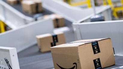 Symbolbild: Peter Steffen
Amazon-Pakete laufen in einem Sortierzentrum über die Bänder.