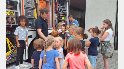Bild: Wulfänger/exb
Interessiert hören die Kinder Michael Wirth zu. Er erläutert das Innenleben einen Einsatzfahrzeuges.
