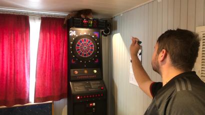 Bild: mis
Unter den Augen ihres Maskottchens, dem Löwen auf dem Dartautomat, zielt Mannschaftsführer Fabian Baldauf auf das Feld der Triple 20 - das punktereichste Feld auf dem Dartboard.