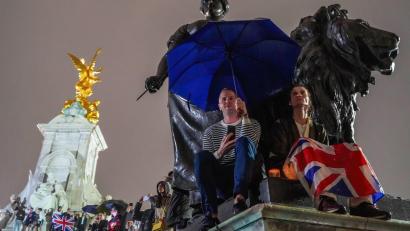 Bild: Jasmine Leung/SOPA Images via ZUMA Press Wire/dpa
Menschen versammeln sich mit Regenschirmen und Flaggen, um Königin Elizabeth II. die letzte Ehre zu erweisen.