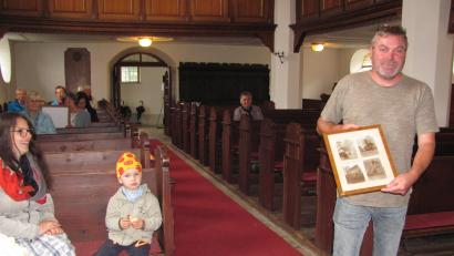 Bild: sei
Harald Stengel, stellvertretender Vertrauensmann der evangelischen Kirchengemeinde, zeigt bei der Führung Fotos, wie die Kirche früher Innen und außen ausgesehen hat.
