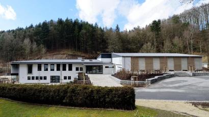 Bild: sche
Das Gemeindezentrum Freudenberg, 2014 in Betrieb genommen, beherbergt bisher im Untergeschoss zwei Krippengruppen. Nun sollen ins derzeit im Rohbau befindliche ehemalige Bettenhaus (rechts) des Hotels Hammermühle zwei weitere Krippengruppen einziehen.