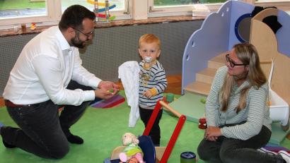 Bild: wro
Bürgermeister Matthias Grundler (links) nutzte die Gelegenheit, um mit Ramona Schmid (rechts) und einem Krippenkind Spielsachen auszuprobieren.