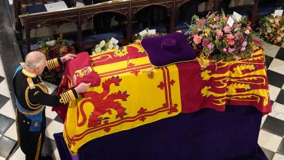 Bild: Jonathan Brady/PA Wire/dpa
König Charles III. legt bei der Beisetzung von Königin Elizabeth II. in der St. Georges Kapelle in Windsor Castle die Kompaniefarbe der Grenadiergarde der Königin auf den Sarg.