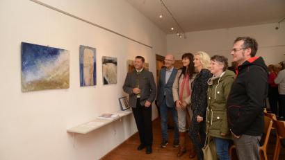 Bild: bey
Bürgermeister Rainer Rewitzer (links), Zweite Bürgermeisterin Andrea Lang (Vierte von links) und Besucher der Vernissage (rechts) bestaunen die Werke von Claudia Biller-Fütterer (Dritte von links). Clemens Fütterer (Zweiter von links) beschreibt die Werke seiner Ehefrau, die verwendeten Materialien und Ideen.