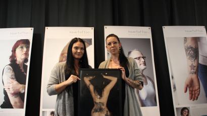 Bild: ads
Jenny Greathous als eine der Protagonistinnen der Ausstellung „Trauertattoo – Unsere Haut als Gefühlslandschaft“ und die Tätowiererin Daniela Hautmann zeigen eines der Bilder der Ausstellung.