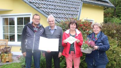 Bild: soj
Kreisfachberater Harald Schlöger (links) und OGV-Vorsitzende Inge Geißler (rechts) überreichten Manfred und Lucia Kratzer Urkunde und Plakette für ihren Naturgarten.