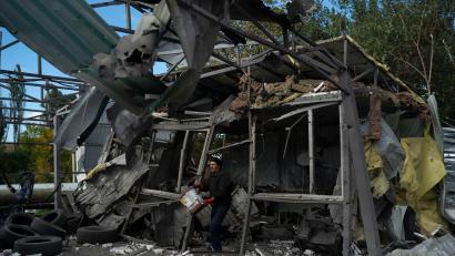 Bild: Leo Correa/AP/dpa
Nach dem russischen Raketenangriff löscht ein Mann in Saporischschja die Überreste eines Feuers in einer zerstörten Autowerkstatt.