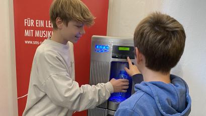 Bild: Lisa Milyukova/SMS/exb
Tim (links) und Theo (rechts) testen schon mal den neuen Wasserspender im SMS-Erdgeschoss.
