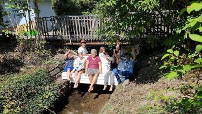 Bild: Ewald Zenger
Eine sogenannte "Doppelsitzbank" nimmt ihren Platz über den Bach ein, damit Sitzende im Sommer ihre Füße im Wasser baumeln lassen können.