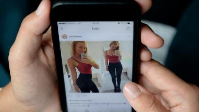 Symbolbild: Monika Skolimowska/dpa
Eine junge Frau schaut sich das Instagram-Profil von Nutzerin Amalie Lee auf dem Display eines Smartphones an. Auf Instagram dokumentiert Lee, die an einer Essstörung leidet, ihren Weg zurück - ihre Heilung.