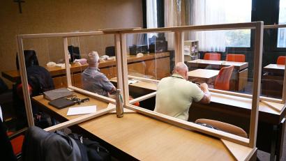 Bild: Angelika Warmuth/dpa
Die beiden Angeklagten warten auf den Prozessbeginn.