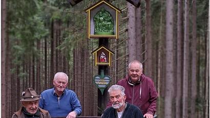 Stammtischkameraden der "Wetterfesten" mit (von links) Roland Herzog, Lorenz Betzl, Hans Rösch und Gerhard Paintner übernahmen den Transport und das Aufstellen der neuen Sitzbank am Flurdenkmal "Grünes Bild".