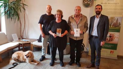 Bild: gi
Bürgermeister Armin Bulenda überreicht an das Ehepaar Eisele den Geldpreis sowie den Naturparkführer für zehnmaligen Aufenthalt in Moosbach. Begleitet werden sie von ihrem Sohn.