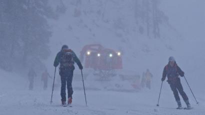 Bild: Carsten Hoefer/dpa
Zwei Skitourengeher und eine Pistenraupe im vergangenen Winter im oberbayerischen Skigebiet Spitzingsee in Oberbayern.