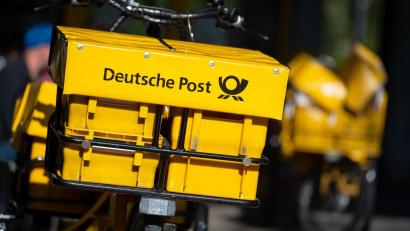 Symbolbild: Sven Hoppe/dpa
Ein Fahrrad von der Deutschen Post steht an einer Straße. Die Post hat massive Probleme bei der Briefzustellung.