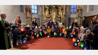 Bild: le
Mit ihren bunten Laternen erhellen die Kinder der Kindertagesstätte „Unterm Regenbogen" das dunkle Gotteshaus St. Johannes Baptista in Floß.